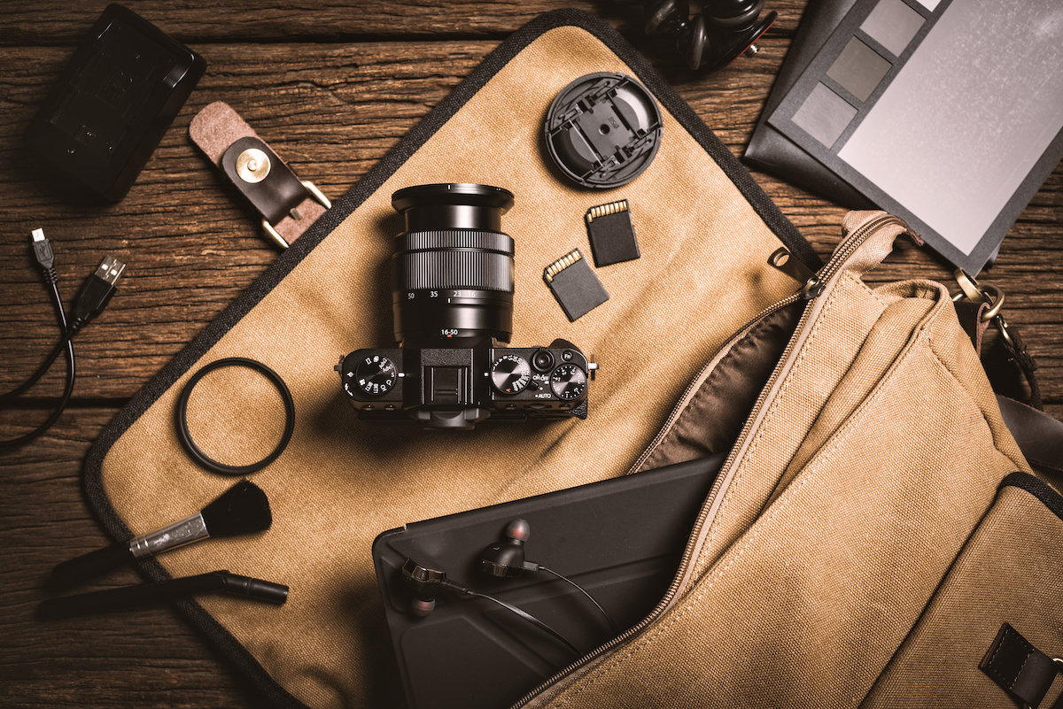 photography gear on wooden table, digital camera lens and other accessories.