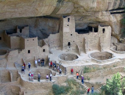 aerial view of visitors at a Cliff Palace, a cliff dwelling set into a mountain overhang