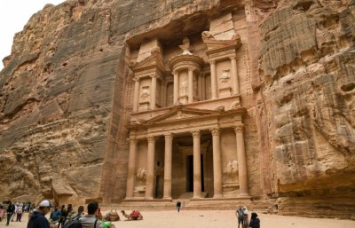 a building facade with columns carved into a wall of rocks in Petra