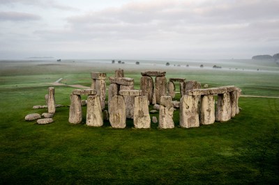 Aerial view of Stonehenge in a verdant landscape, a post-and-lintel style circular stone structure