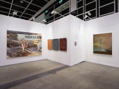 View of an art fair booth showing one large painting on a one wall, three works on another, and a photograph on a third wall.