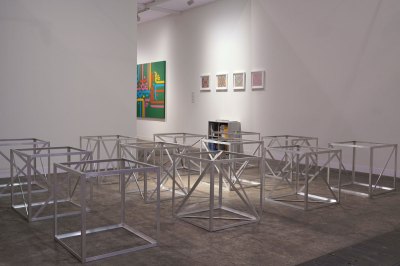 View of an art fair booth showing various silver cubes that are hallow.