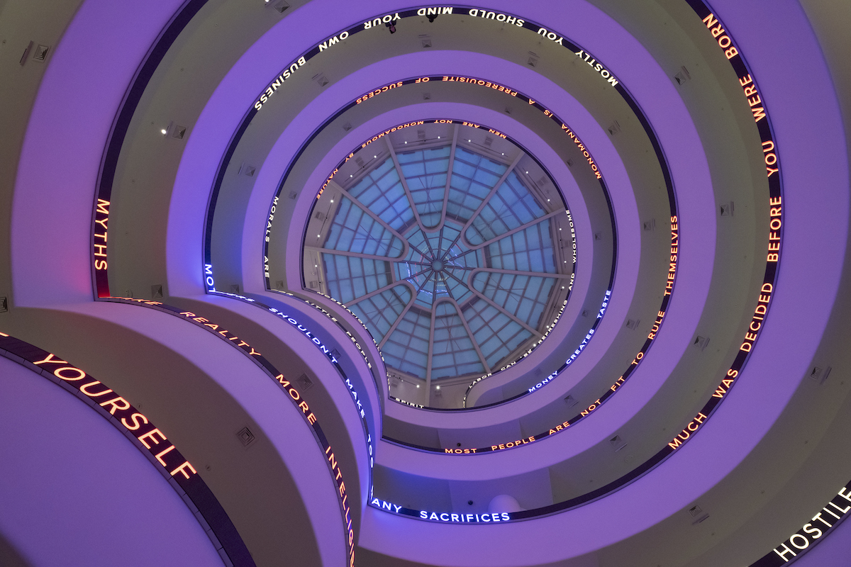 A purple-tinted rotunda whose walls are ringed with text on a long LED screen.