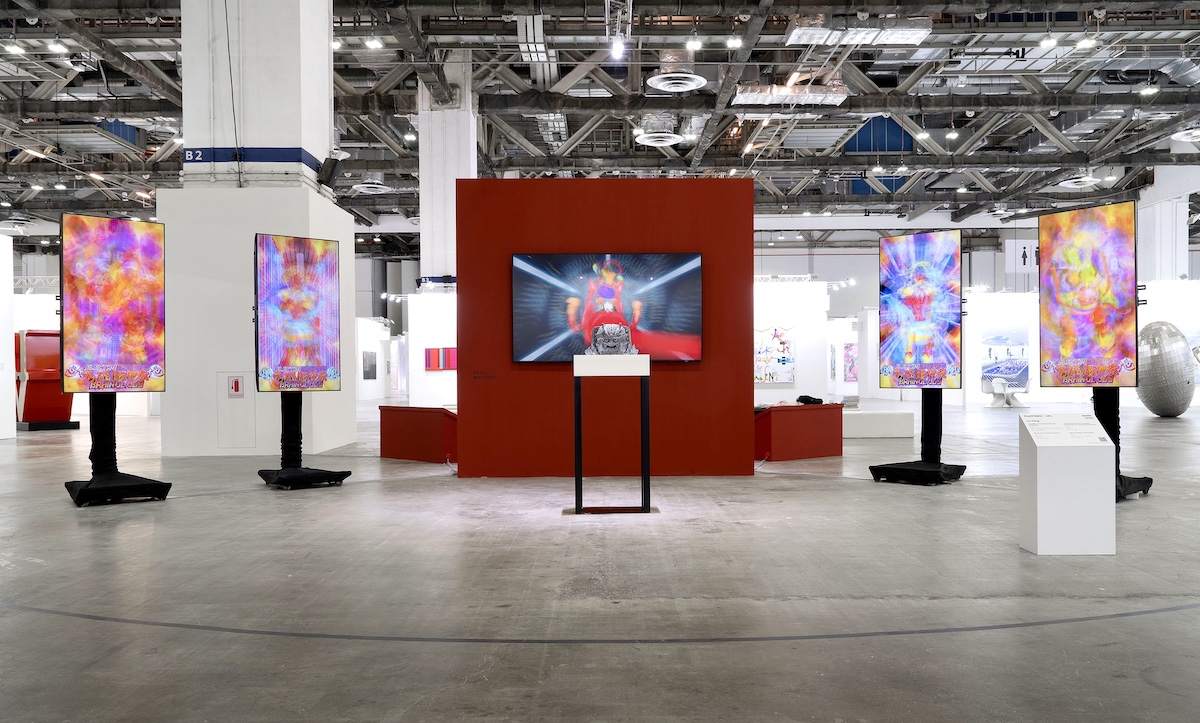 A five-channel video installation with four of its screens showing a phantasmagoria of colors and the fifth, central one displaying what appears to be a deity.