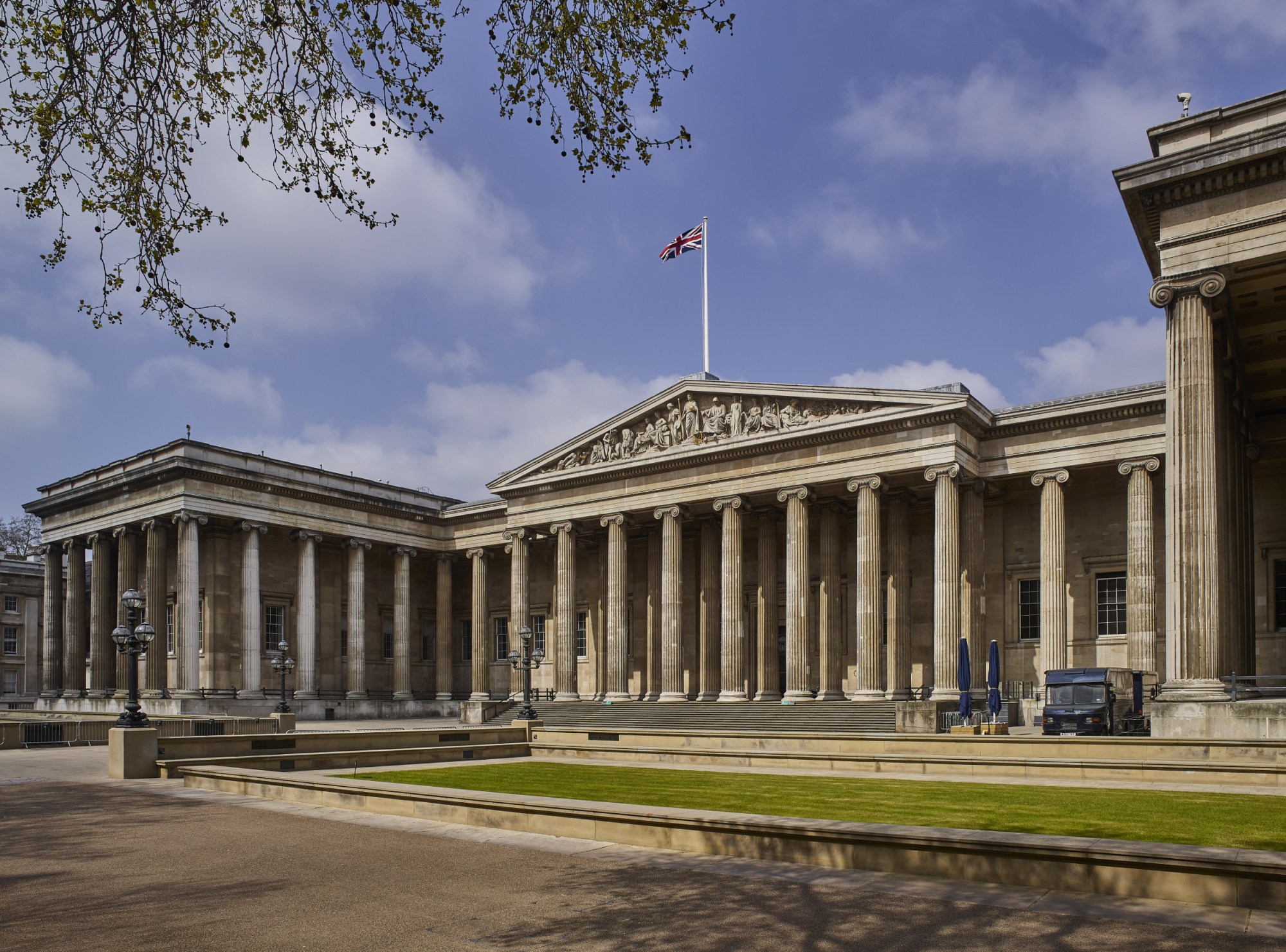 An empty museum facade pictured against a cloudy sky.